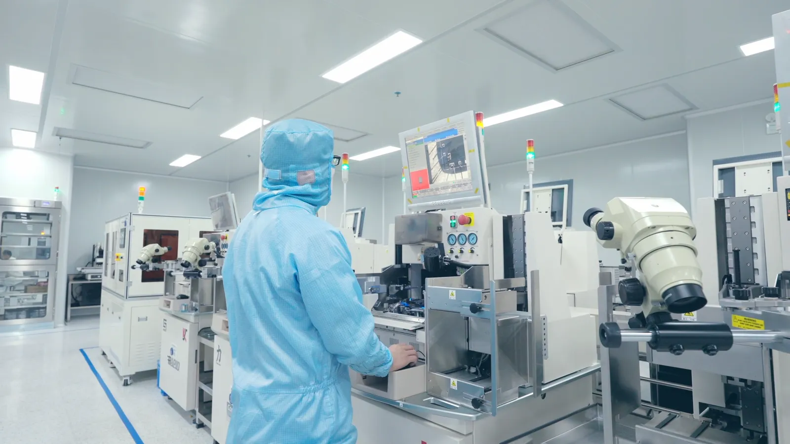 Operator in a cleanroom monitoring chip placement on the FAELAN core-component line